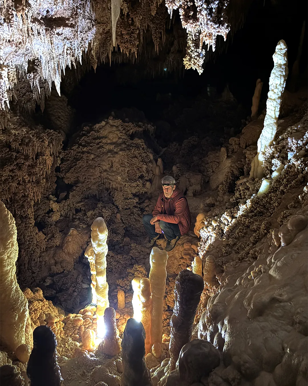 visiteur devant les stalagmites éclairées