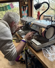 artisan qui meule une pierre dans son atelier sur une machine